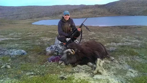 woman holding rifle with yak kill