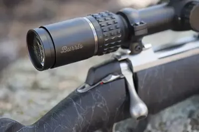 Close up of end of a Burris riflescope mounted on a bolt-action rifle
